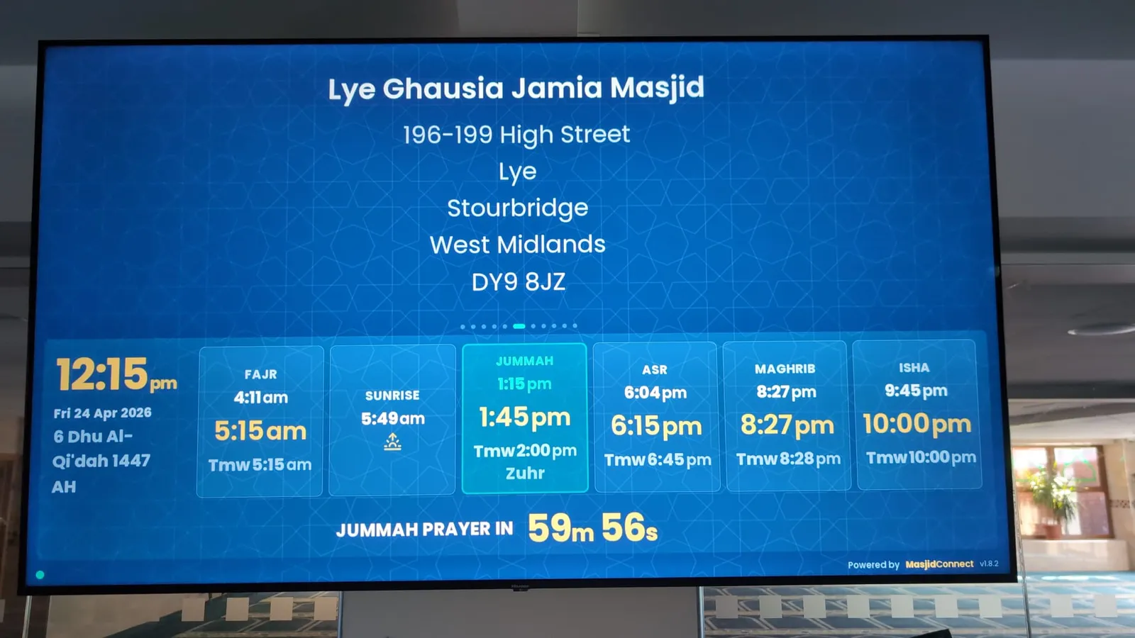 A MasjidConnect screen with the day's prayer times, fitted above the hall entrance at Lye Ghausia Jamia Masjid